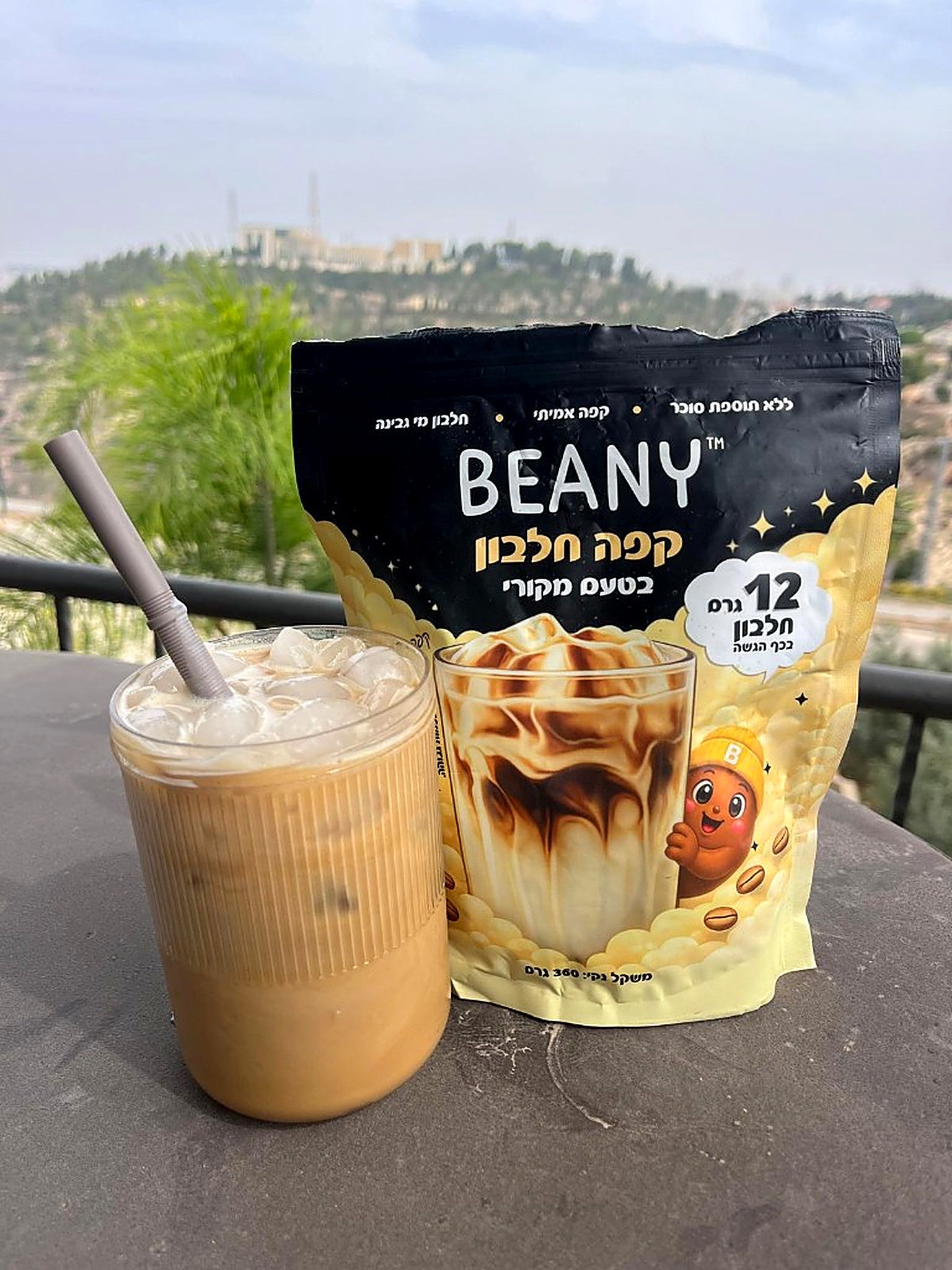 קפה חלבון BEANY בטעם מקורי ליד כוס קפה קר